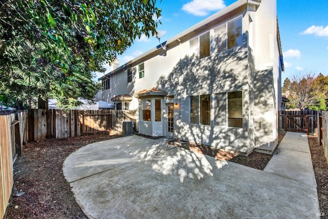 rear view of house featuring central air condition unit, a patio, a fenced backyard, and stucco siding