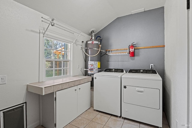 clothes washing area featuring washing machine and clothes dryer, gas water heater, and light tile patterned floors