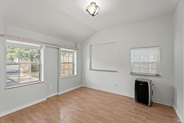 unfurnished room with vaulted ceiling and light hardwood / wood-style flooring