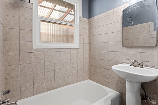 bathroom featuring tile walls, backsplash, sink, and a bath