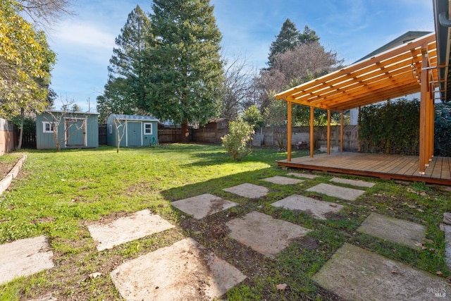 view of yard with a storage unit, a pergola, and a deck