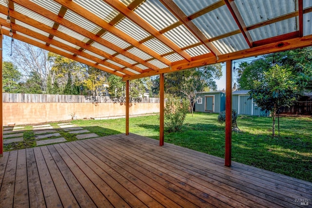 deck with a pergola, a lawn, and a storage unit