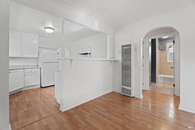 kitchen featuring white cabinetry, white fridge, crown molding, and light hardwood / wood-style floors