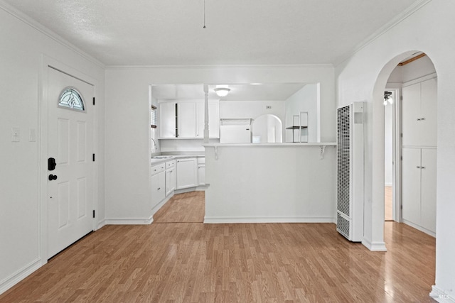 foyer featuring crown molding, sink, a textured ceiling, and light wood-type flooring