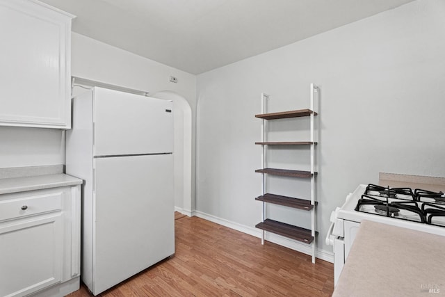 kitchen featuring white cabinetry, white appliances, and light hardwood / wood-style flooring