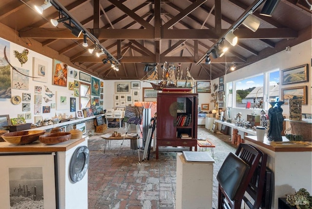 interior space with vaulted ceiling with beams and rail lighting