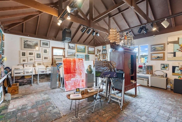 miscellaneous room featuring beamed ceiling, high vaulted ceiling, and track lighting