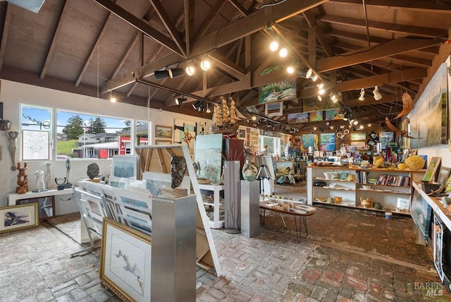 miscellaneous room featuring high vaulted ceiling, beamed ceiling, and a workshop area