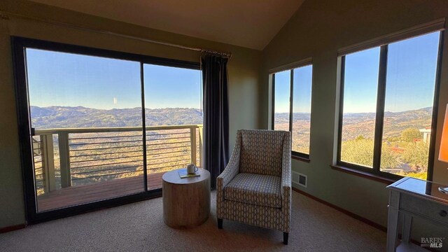 sitting room with lofted ceiling, a mountain view, carpet flooring, visible vents, and baseboards