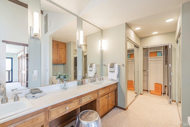 full bathroom with a walk in closet, visible vents, a sink, and double vanity