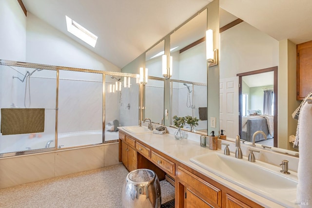 ensuite bathroom with vaulted ceiling with skylight, combined bath / shower with glass door, a sink, and double vanity