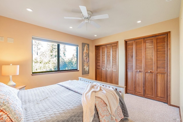 bedroom featuring carpet floors, a ceiling fan, multiple closets, and recessed lighting