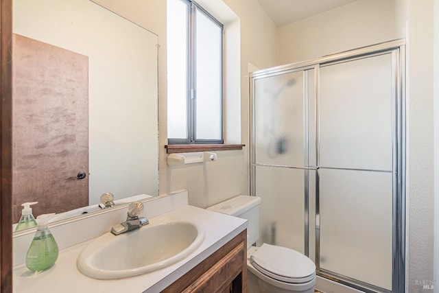 bathroom featuring a shower stall, toilet, and vanity