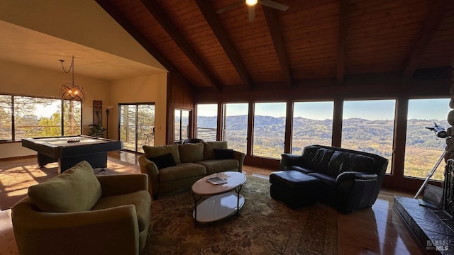 living area with pool table, a mountain view, wood finished floors, wooden ceiling, and beamed ceiling