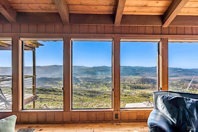 interior space with a wealth of natural light, wooden ceiling, and a mountain view