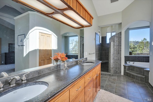 bathroom featuring tile patterned flooring, a wealth of natural light, vanity, and plus walk in shower