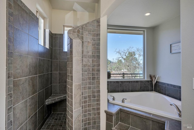 bathroom featuring independent shower and bath