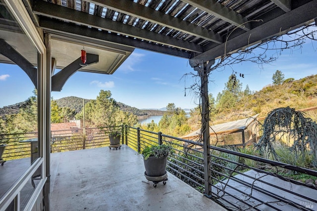 view of patio featuring a balcony and a water view