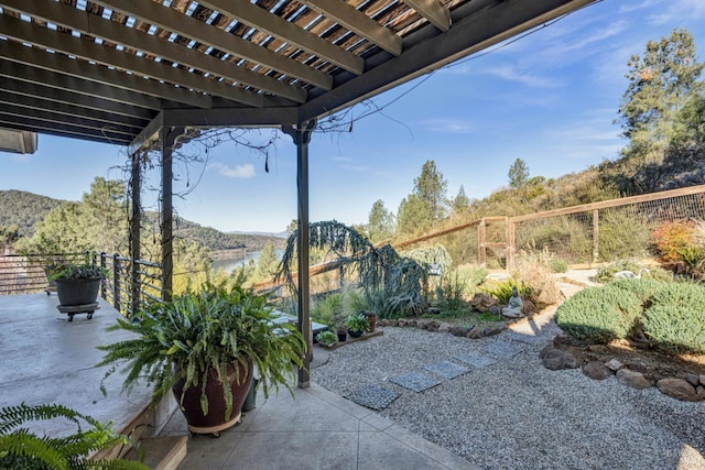 view of patio with a water view and a pergola