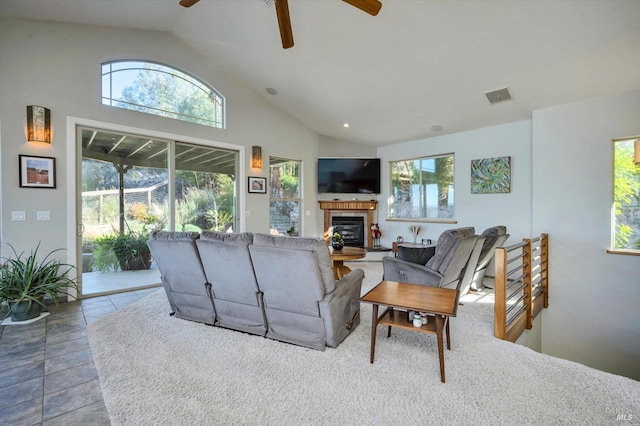 tiled living room featuring a fireplace, vaulted ceiling, and ceiling fan