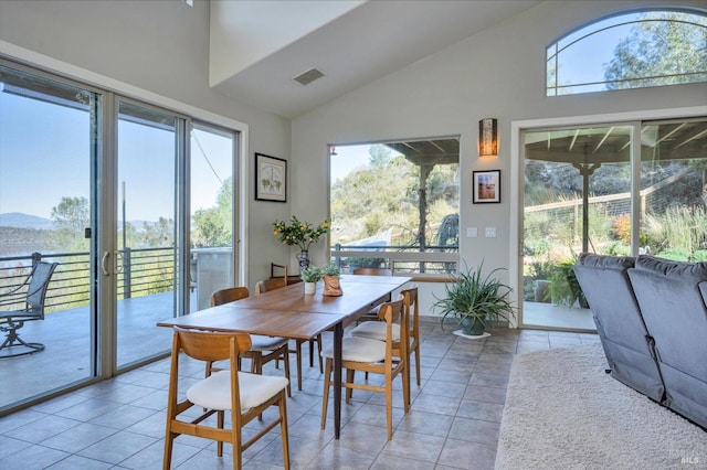 dining room with vaulted ceiling and light tile patterned floors