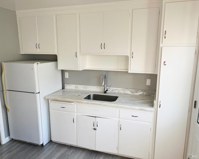 kitchen featuring sink, white cabinets, dark hardwood / wood-style flooring, and white fridge