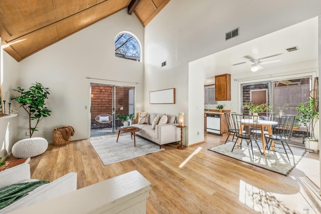 living room with light hardwood / wood-style floors, a wealth of natural light, high vaulted ceiling, and ceiling fan