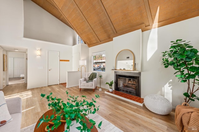 living room with beamed ceiling, hardwood / wood-style flooring, high vaulted ceiling, wooden ceiling, and a tile fireplace