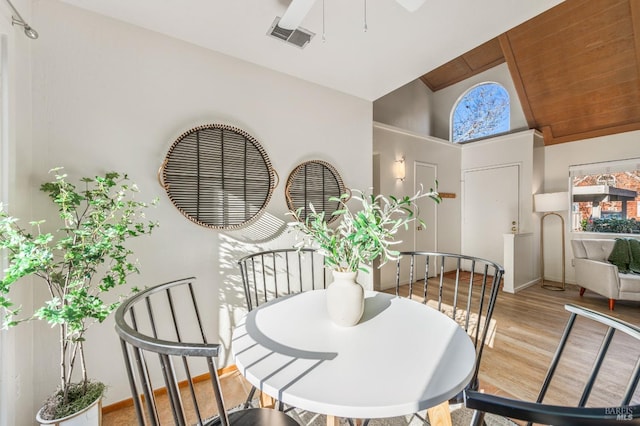 dining area featuring high vaulted ceiling and light hardwood / wood-style flooring