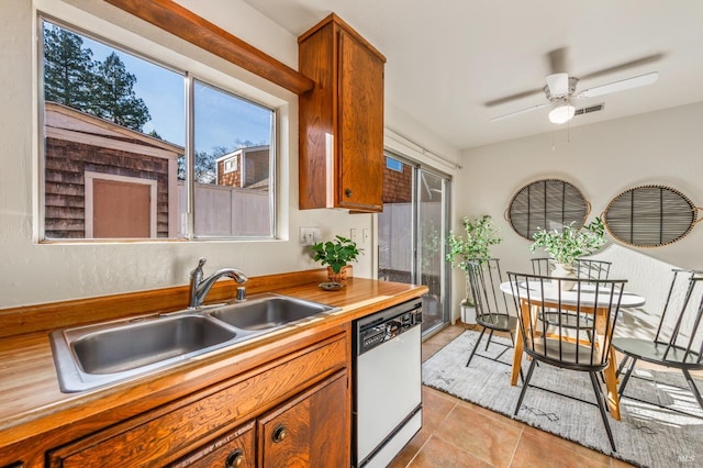 kitchen featuring sink, light tile patterned flooring, a healthy amount of sunlight, and dishwasher