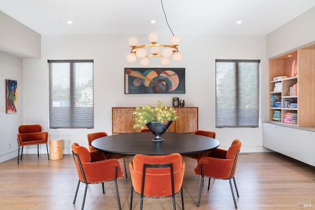 dining space featuring light hardwood / wood-style floors and a chandelier