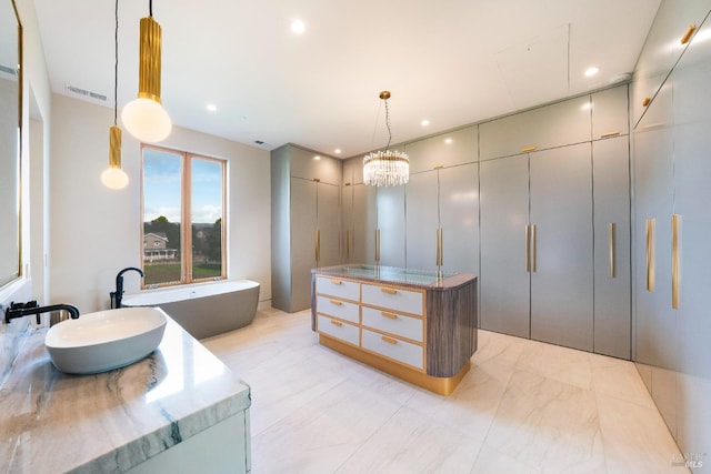 spacious closet with sink and a chandelier