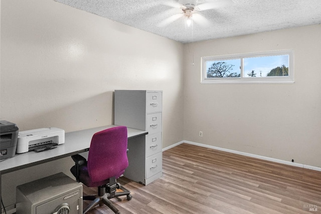 home office with light hardwood / wood-style floors, a textured ceiling, and ceiling fan