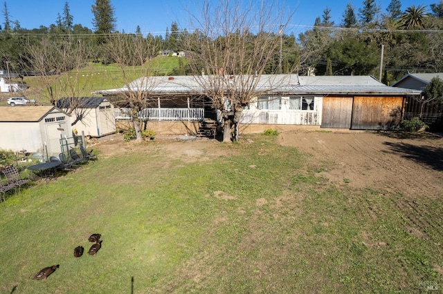 back of property with a yard and a storage shed