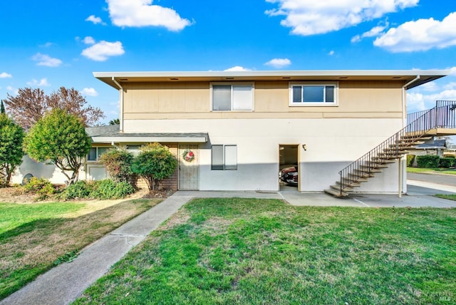 rear view of property featuring a lawn