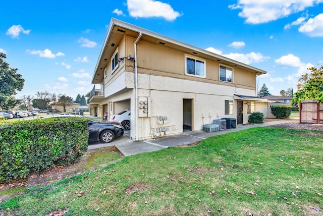 back of house with a garage and a lawn