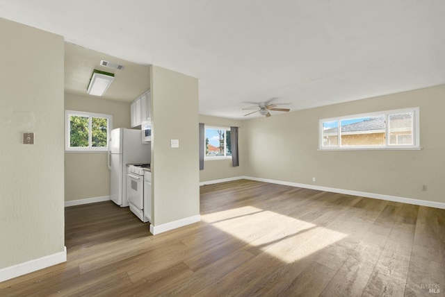 unfurnished living room with ceiling fan and wood-type flooring