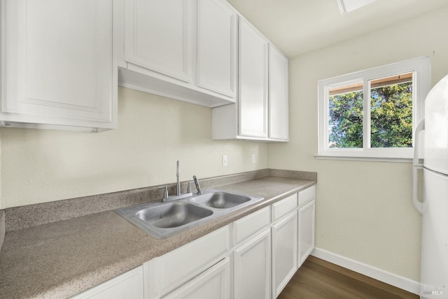 kitchen featuring white cabinetry, sink, dark hardwood / wood-style flooring, and white refrigerator