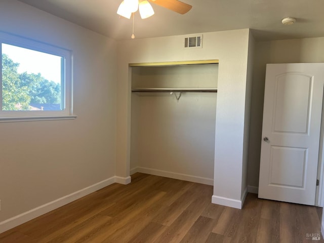 unfurnished bedroom featuring hardwood / wood-style flooring, ceiling fan, and a closet