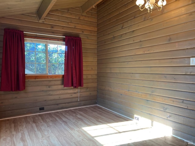 unfurnished room with light wood-type flooring, wood walls, lofted ceiling with beams, and an inviting chandelier