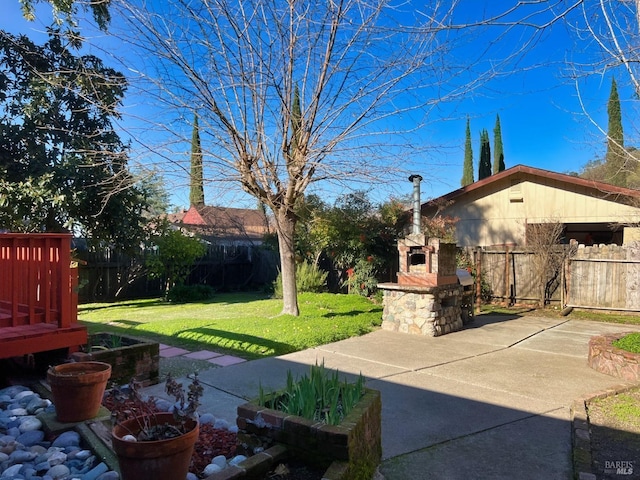 view of yard featuring a patio and an outdoor stone fireplace