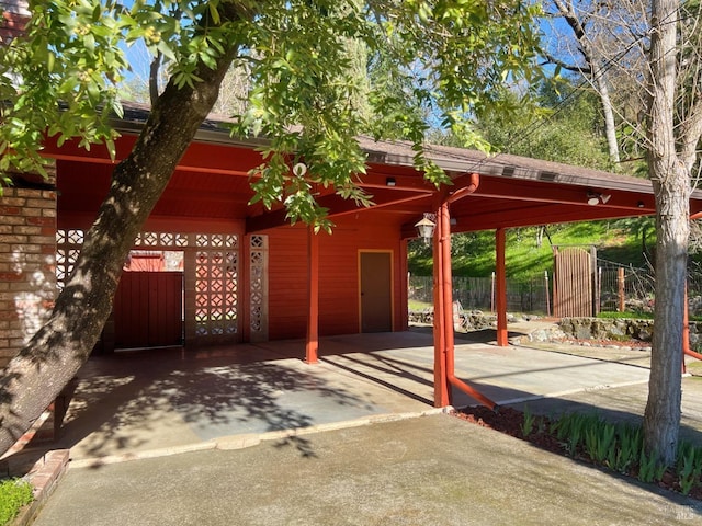 view of patio with an attached carport and fence