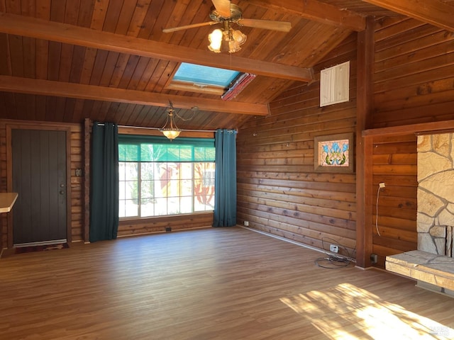 unfurnished living room with vaulted ceiling with skylight, a ceiling fan, wooden ceiling, wood finished floors, and wood walls