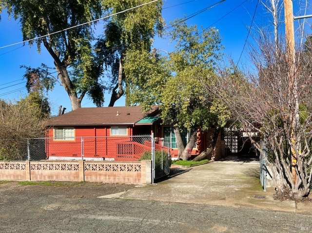 view of front facade with concrete driveway and fence