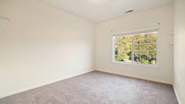 unfurnished room featuring carpet, visible vents, and baseboards