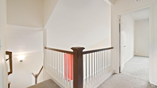 hall featuring carpet floors and an upstairs landing