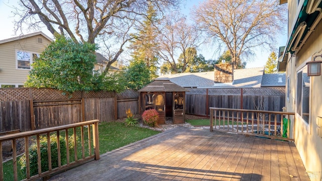 wooden terrace featuring a fenced backyard and a lawn