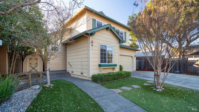 view of front of house with a garage, a storage shed, concrete driveway, fence, and a front yard