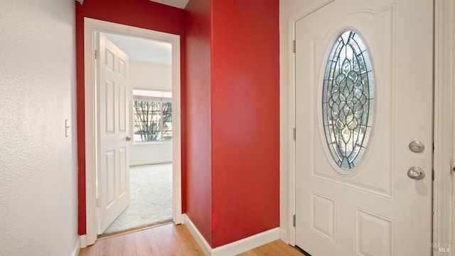 foyer entrance featuring light wood-style flooring and baseboards