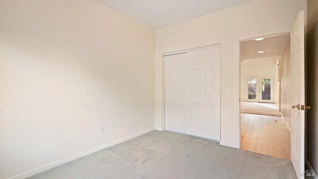 unfurnished bedroom with carpet, baseboards, and a closet